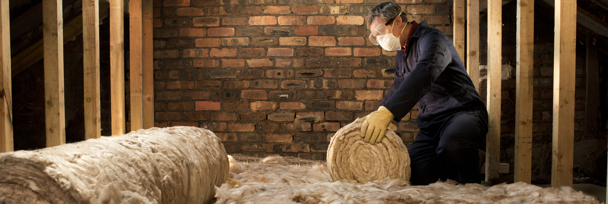 man rolling out insulation