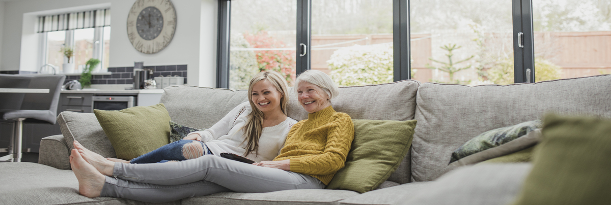 A family sitting looking happy on their sofa