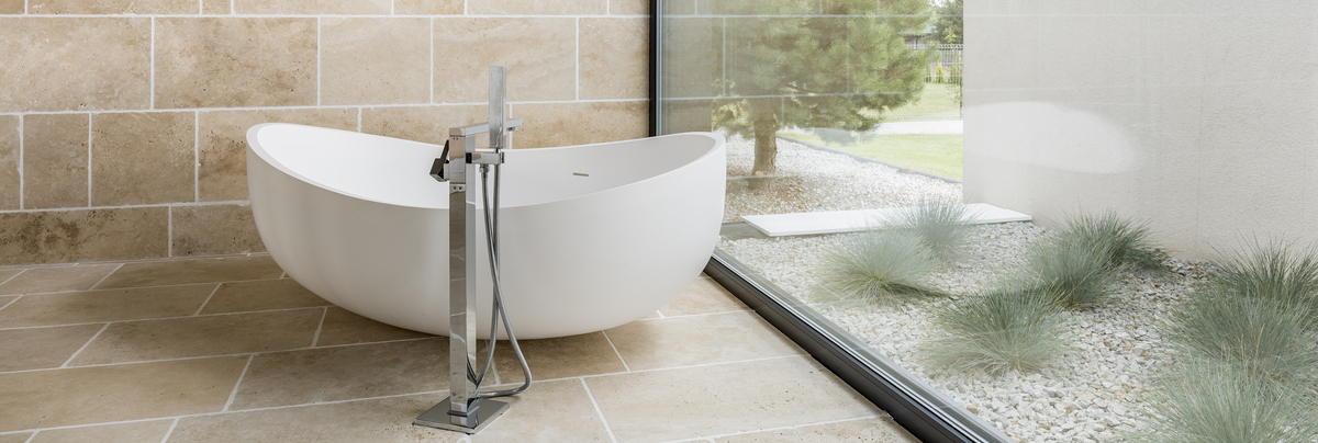 A free standing bath and tap in a neutral bathroom