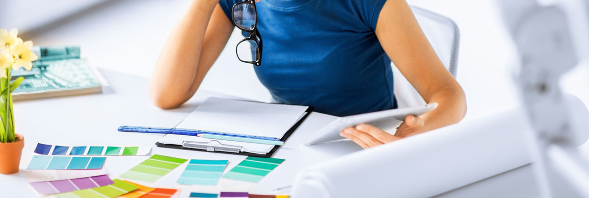 Woman using colour cards and tablet to research future colour scheme