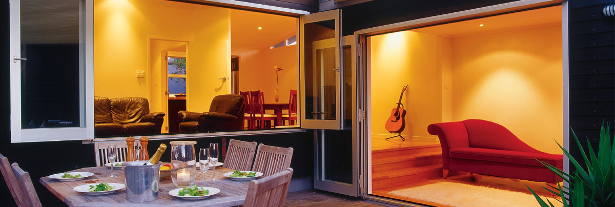 Windows and doors opening up from living room to outdoor patio.
