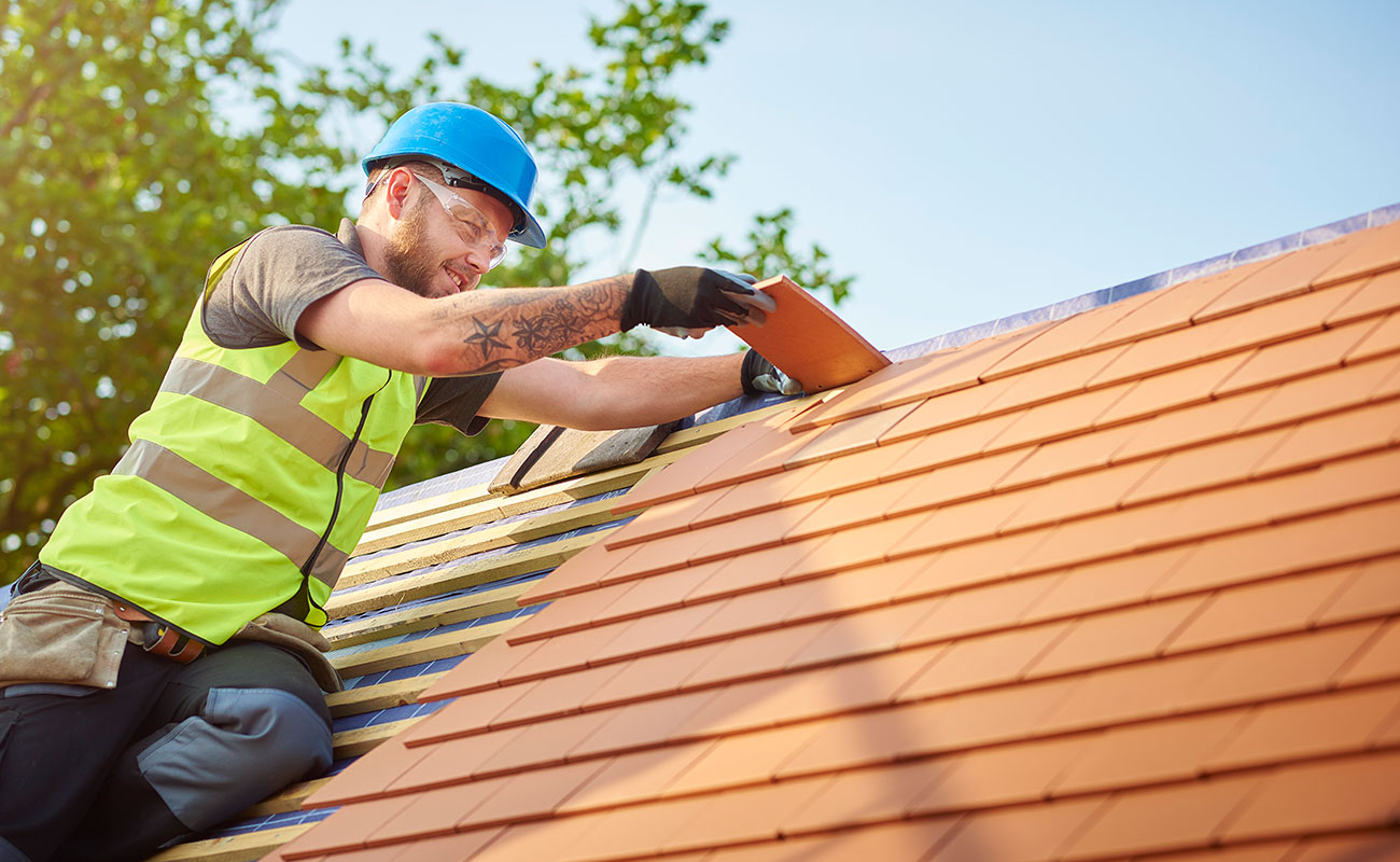 man installing plain tiles