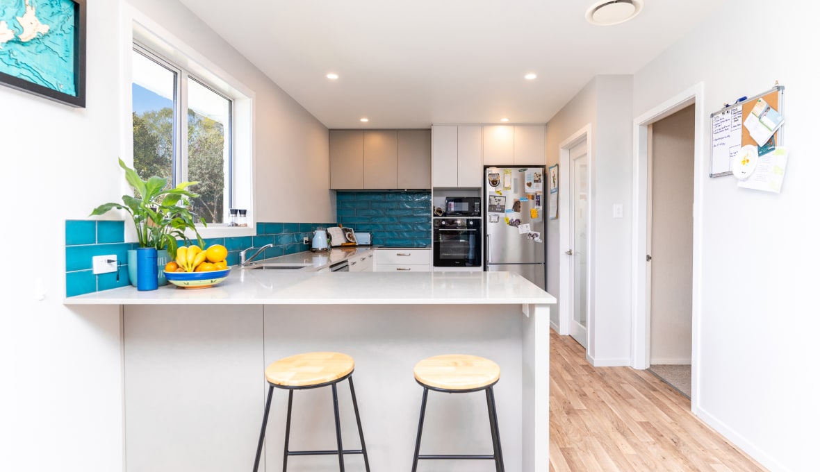 A kitchen with aqua tiled kitchen