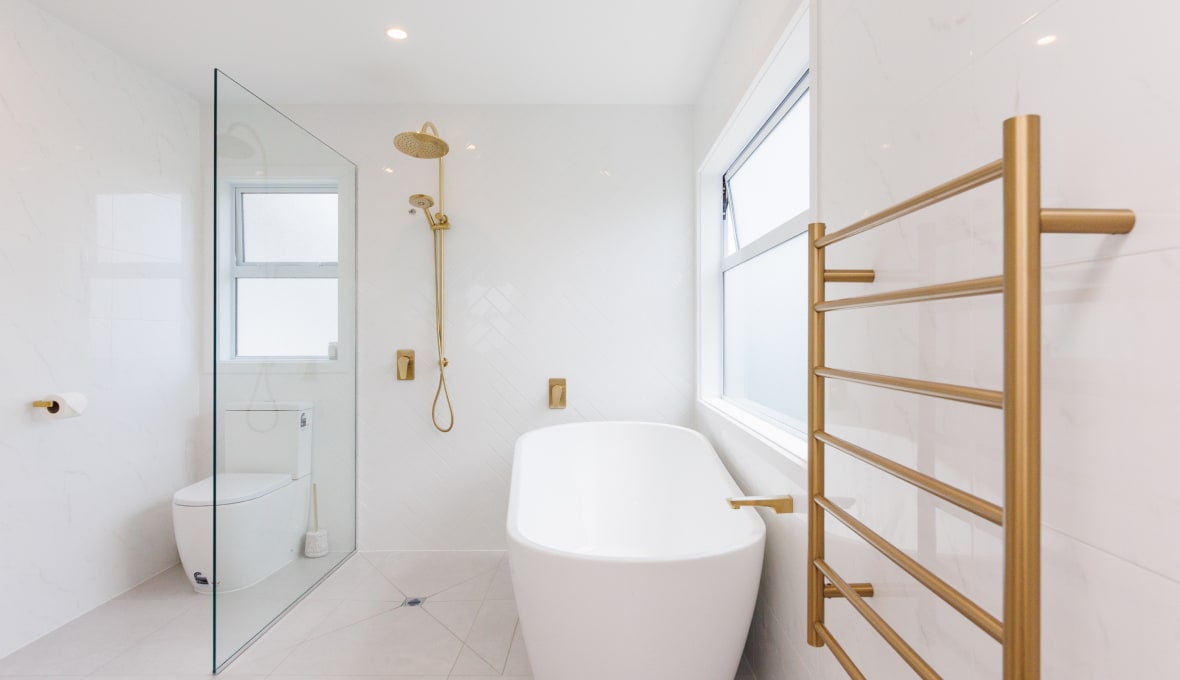 Modern white tiled Bathroom Renovation with brass fixtures that give a luxury feel.