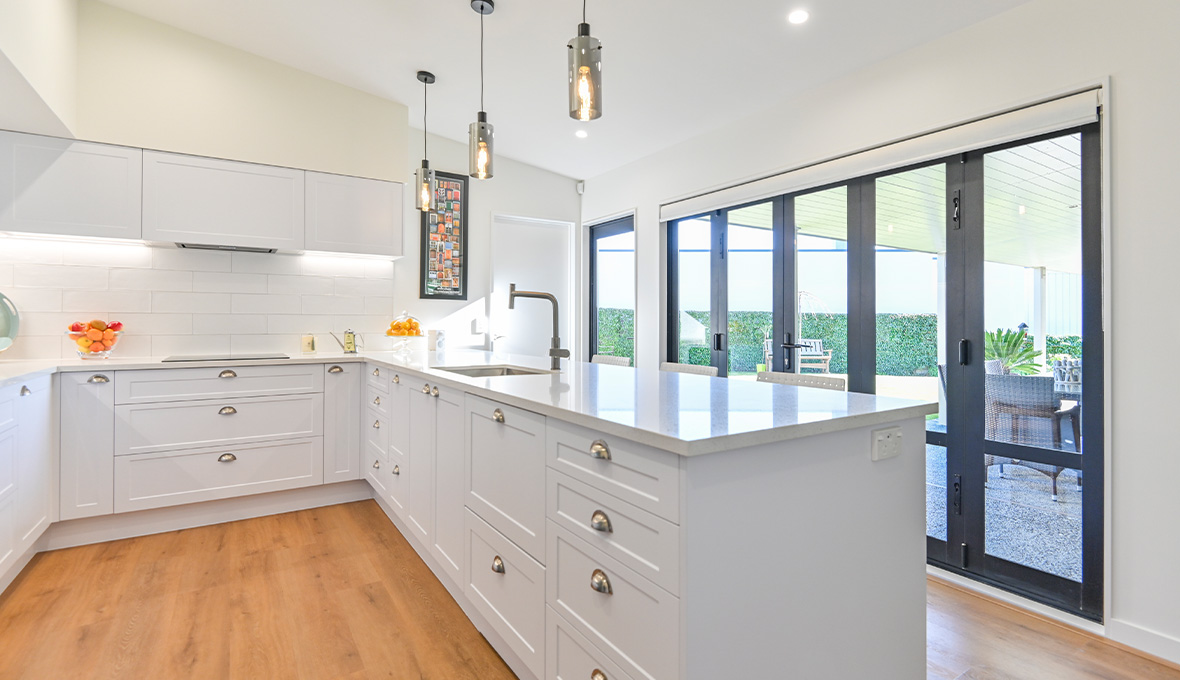 Complete white kitchen renovation in Nelson with modern sink and half moon drawer handles