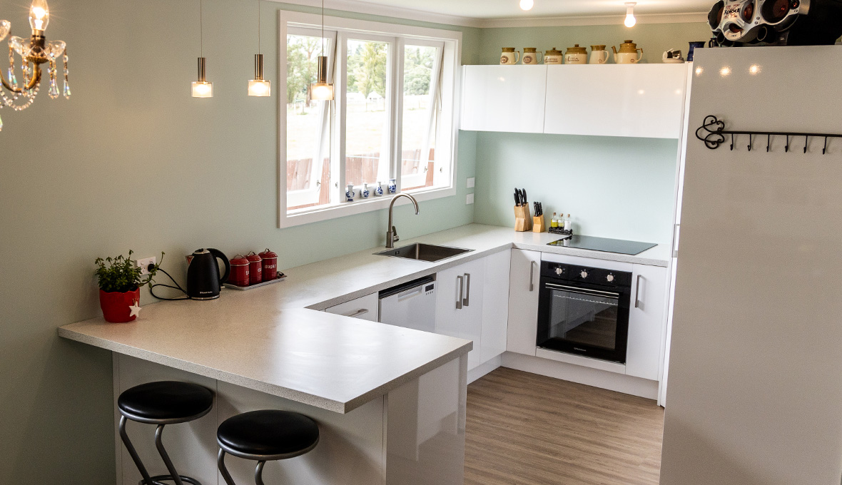 Small kitchen renovation with light green painted walls and 3 pendant lights