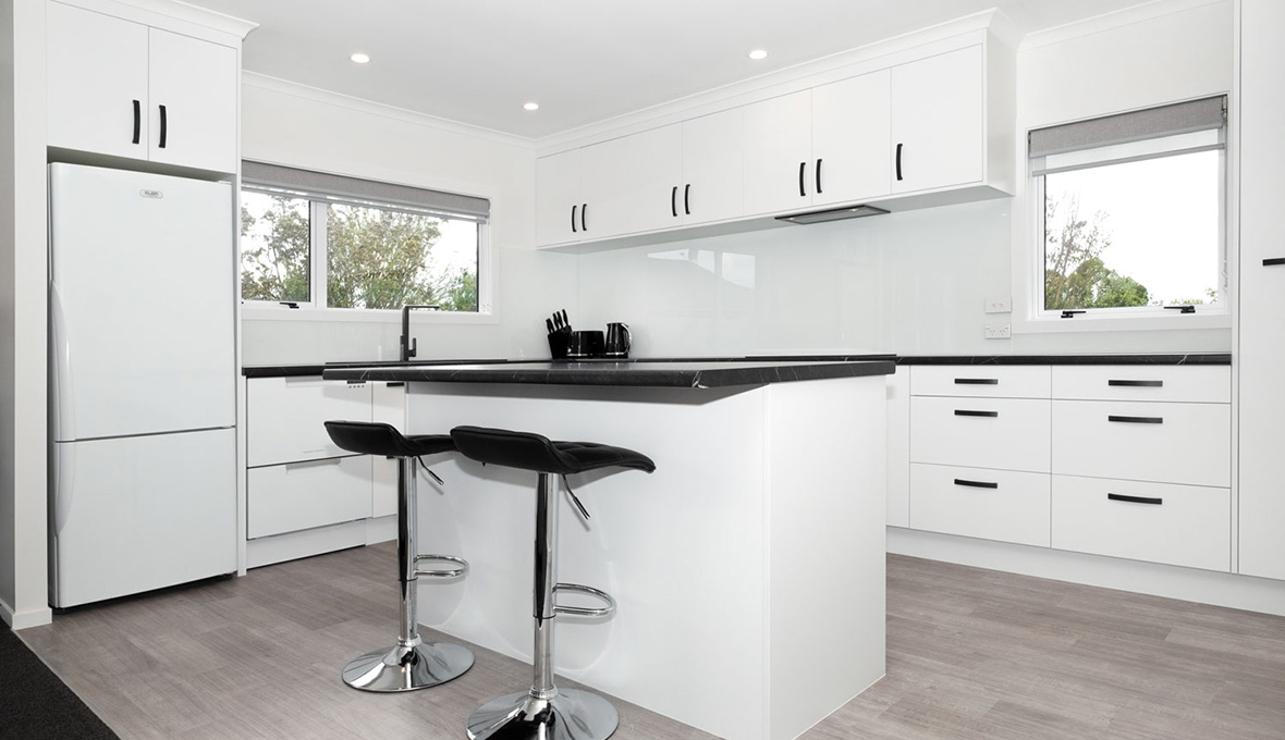 Island kitchen benchtop surrounded by ample white kitchen cabinets.