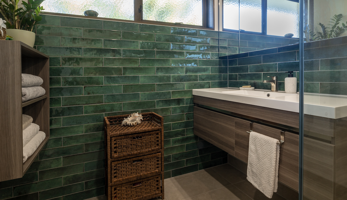 Dark Green tiled bathroom with a dark wood wall vanity