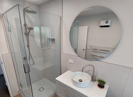 Circular mirror and white vanity