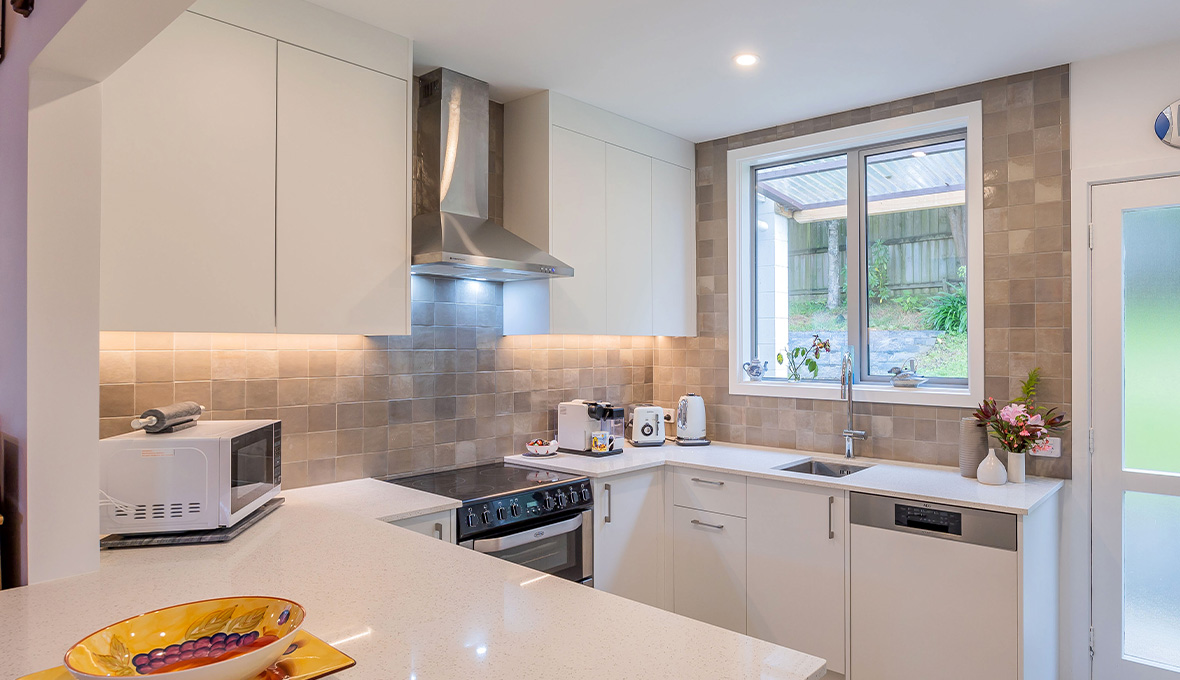 White kitchen renovation in Ellerslie, West Auckland with kitchen range hood and electric cooktop