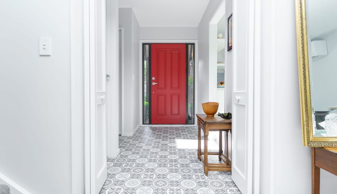 A bright red front door surrounded by white and grey colours from a full home renovation in Riccarton.