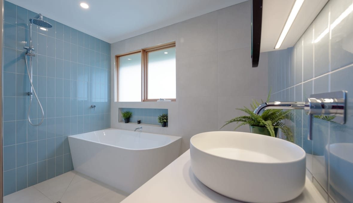 Modern bathroom renovation with a small bathtub with olive basin sink in Nelson
