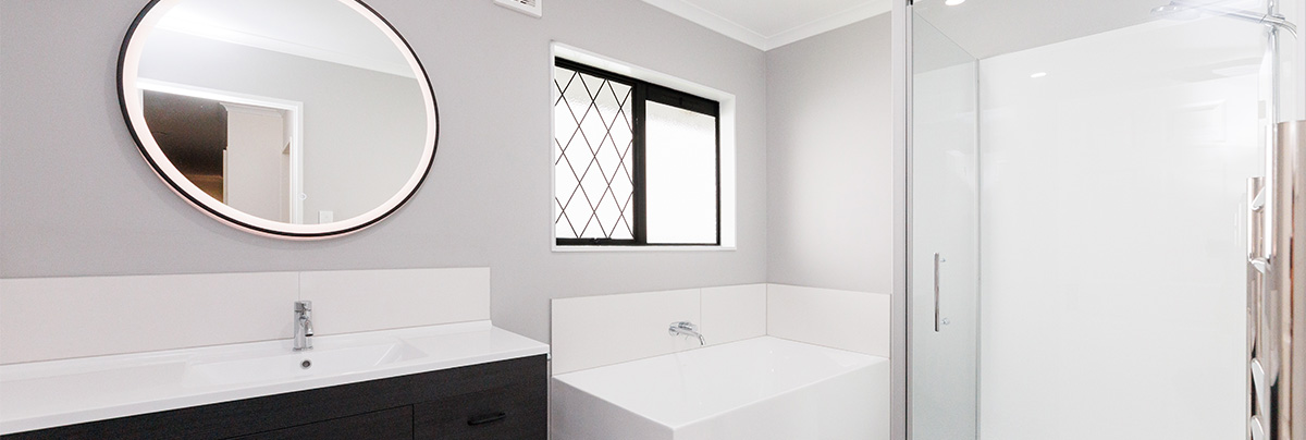 bathroom renovations palmerston north with round mirror and modern bathtub