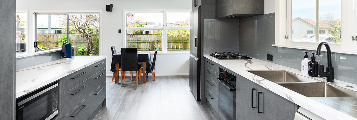 galley kitchen with grey cabinets and marble bench top
