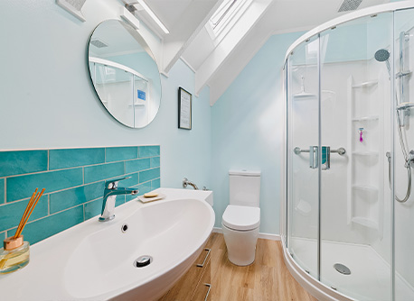small bathroom with sloped ceilings and turquoise tiles