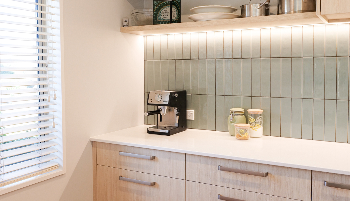 Green splashback with coffee machine in front