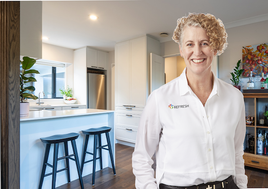 Maree in front of her kitchen renovation