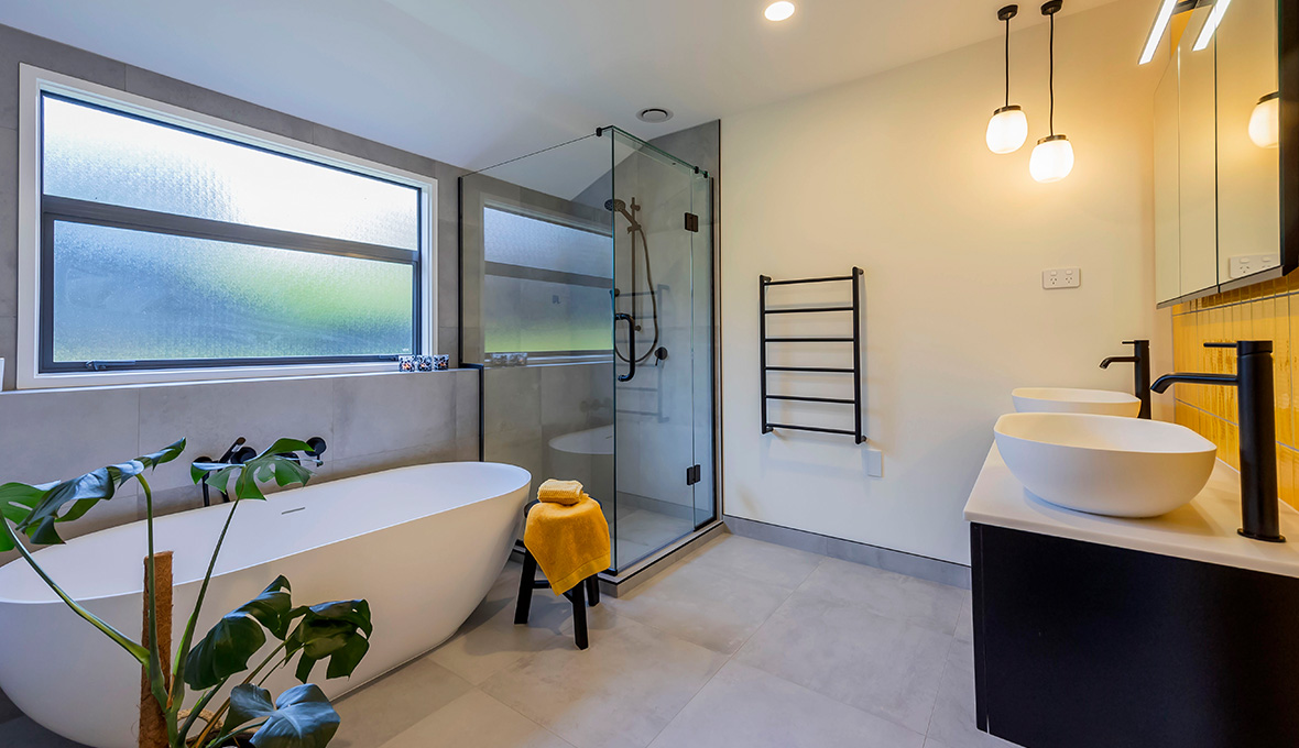 bathroom renovation in west auckland with black frame and a cove free standing bath tub
