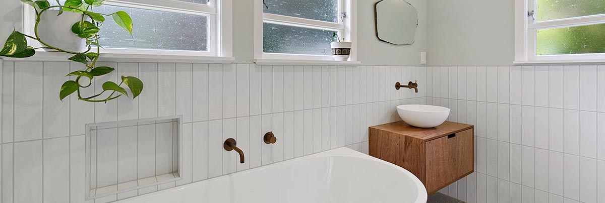 Bathroom with freestanding tub and white wall tiles