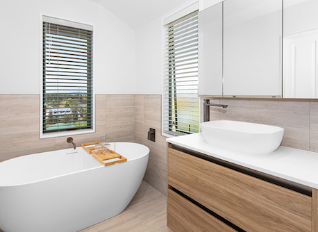 Freestanding bathtub with timber vanity cupboards
