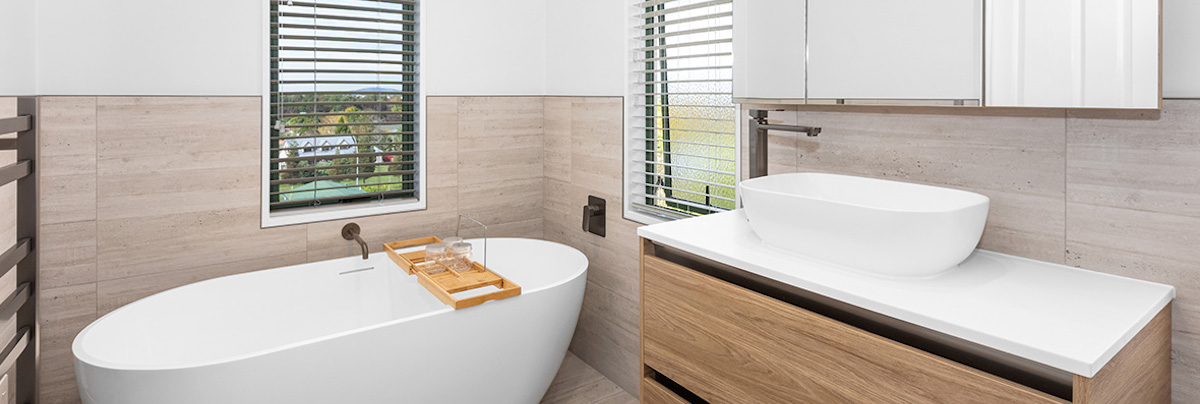 Freestanding bathtub with timber vanity cupboards