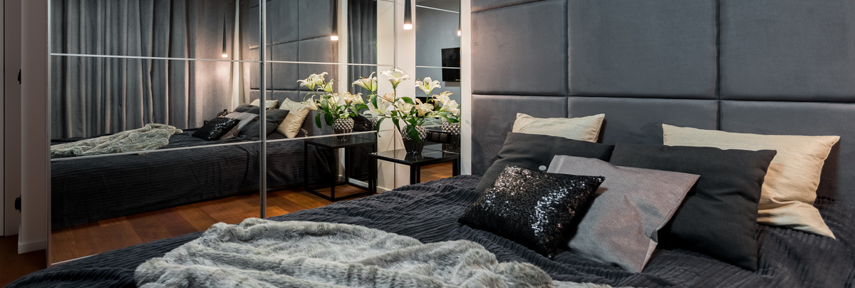 A bedroom with mirrored walls to make it look larger