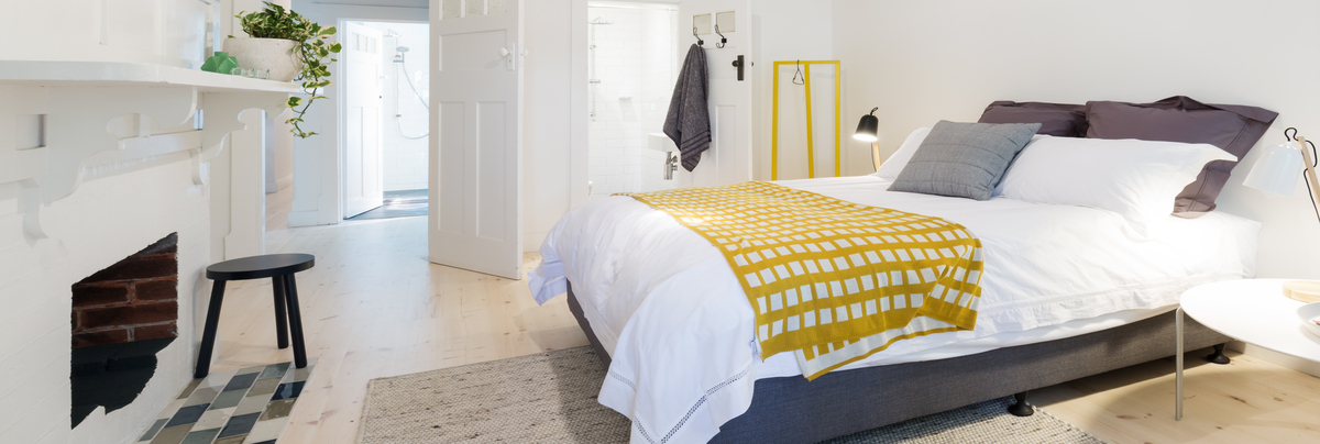 A bedroom that has an en-suite bathroom and view to the landing