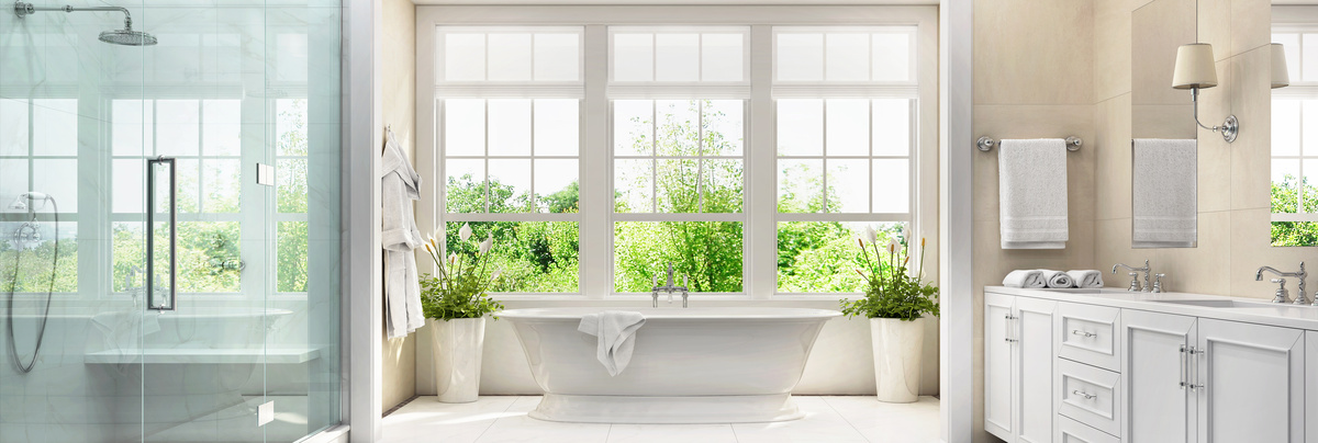 A large bathroom with a bath overlooking the back garden.