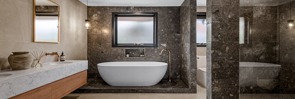 Freestanding bath tub with marble floor to ceiling tiling