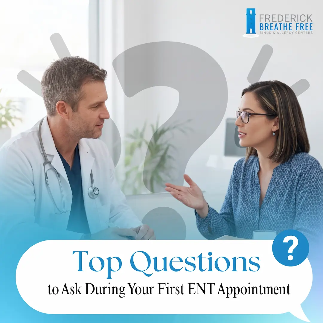 A doctor in a white coat listening as a patient in a blue blouse speaks during a consultation.