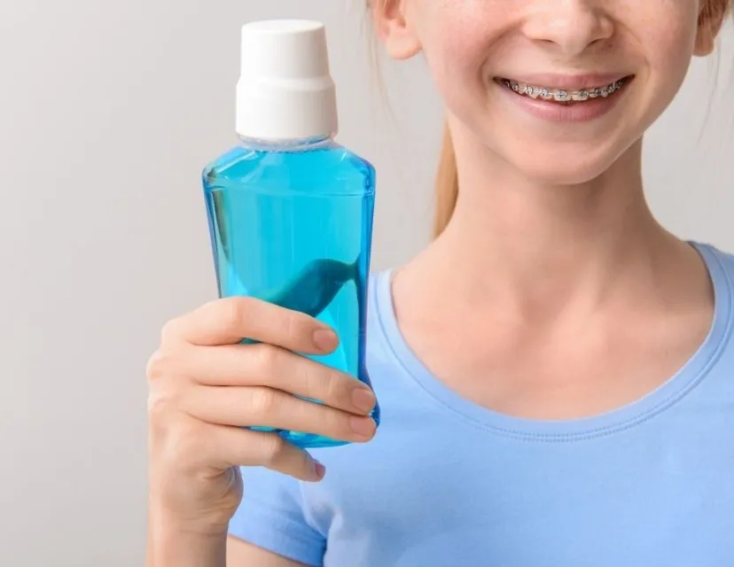 Child holding a bottle of mouthwash