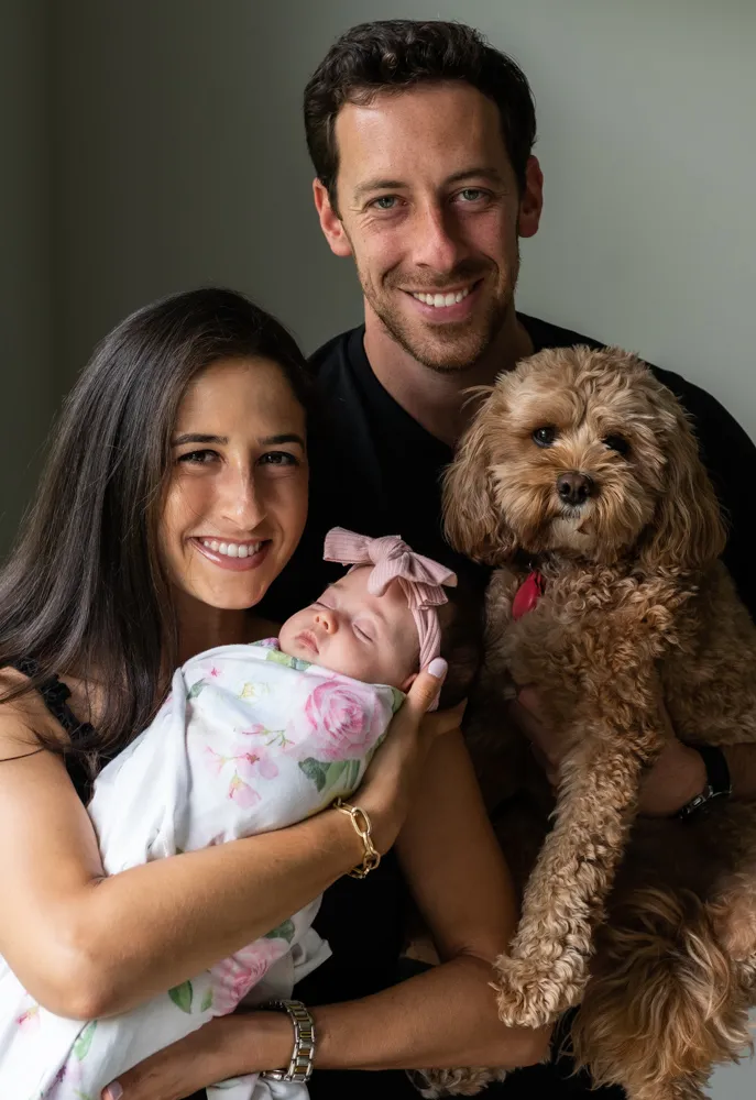 Man and women holding small baby and dog
