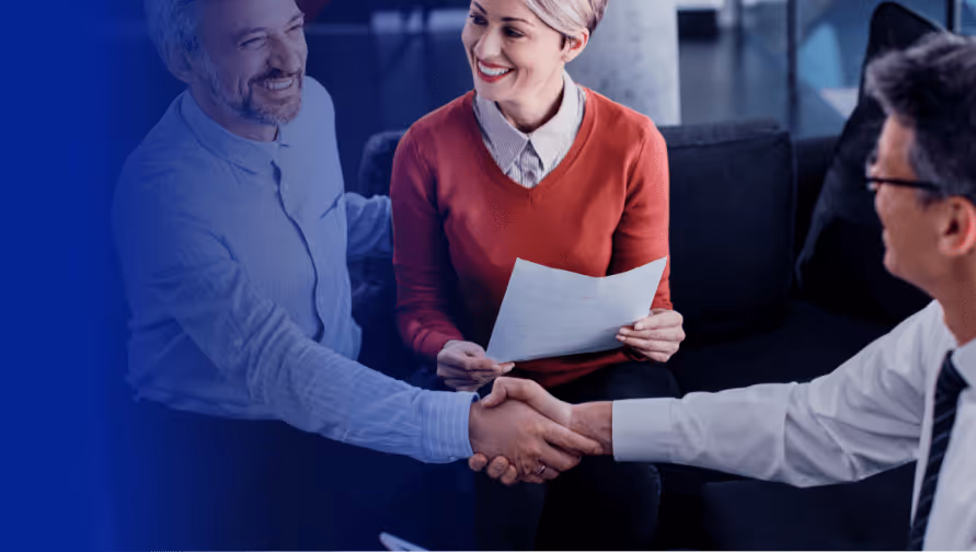 Business professionals shaking hands during a meeting, discussing cybersecurity solutions for the insurance industry.