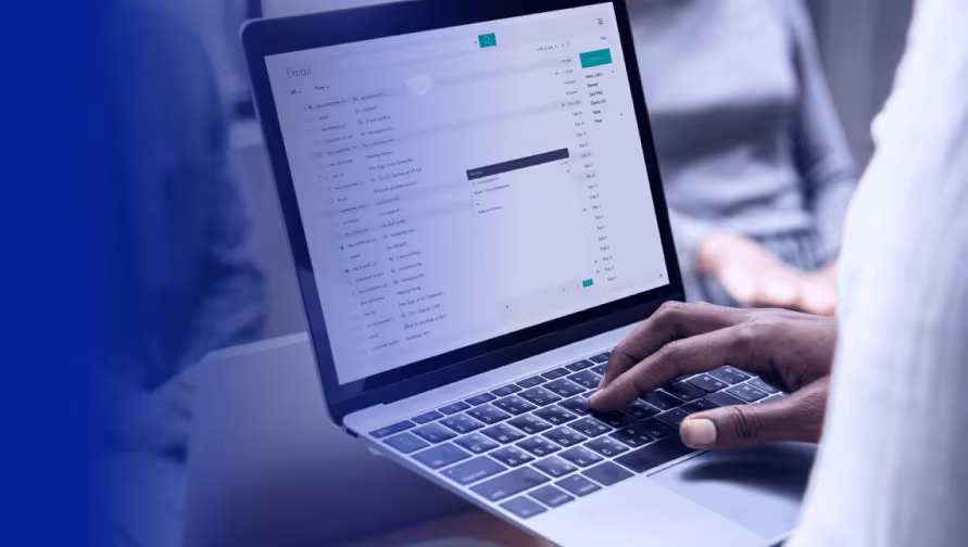 User interacting with a laptop displaying an email interface, highlighting SaaS security solutions.