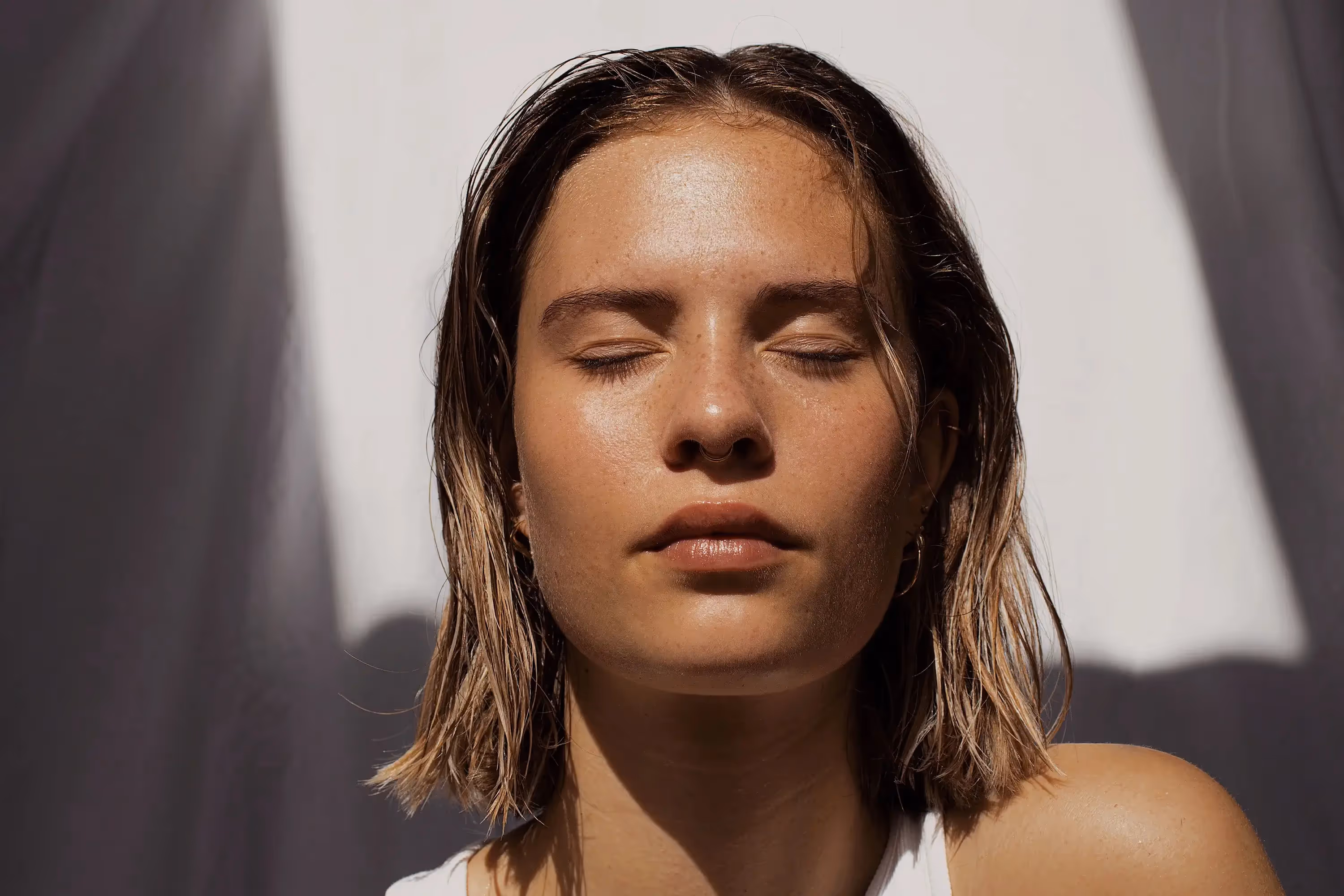 a woman with her eyes closed facing the sun