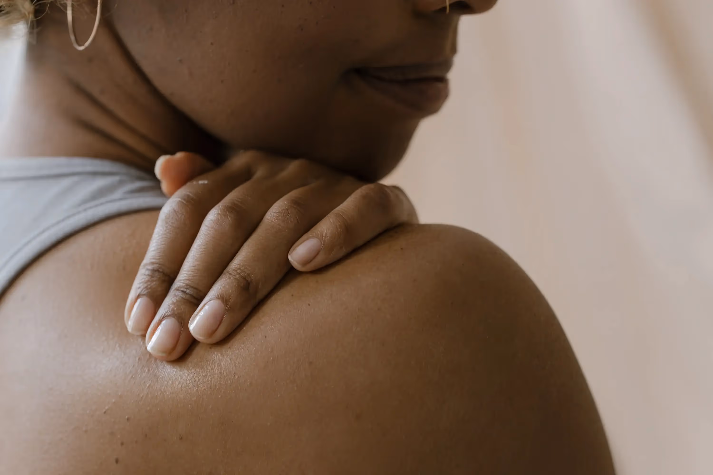 a person's hand touching their own shoulder