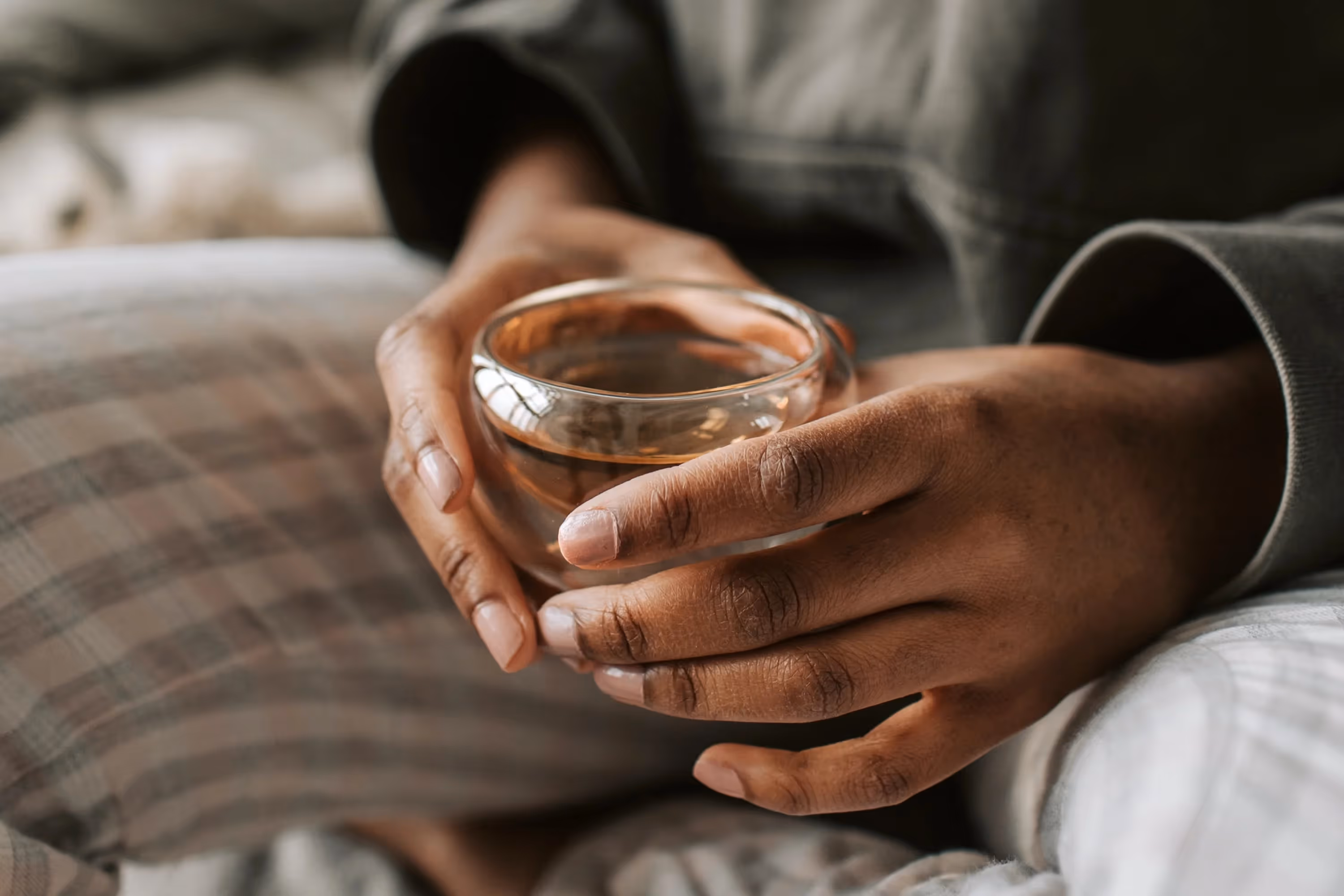 hands holding a cup of black tea