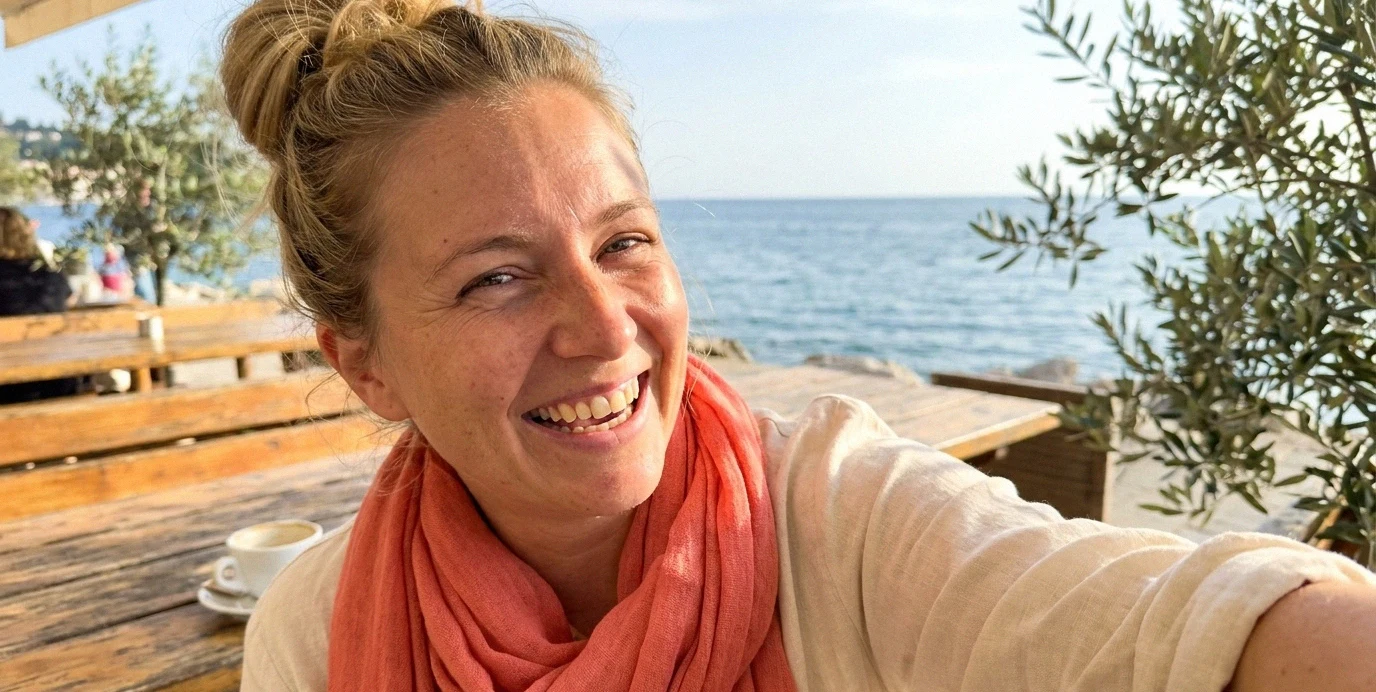 Zadovoljna ženska se sproščeno smeji na prostem, saj ji bela plomba omogoča brezskrbno uživanje v hrani brez zatikanja.