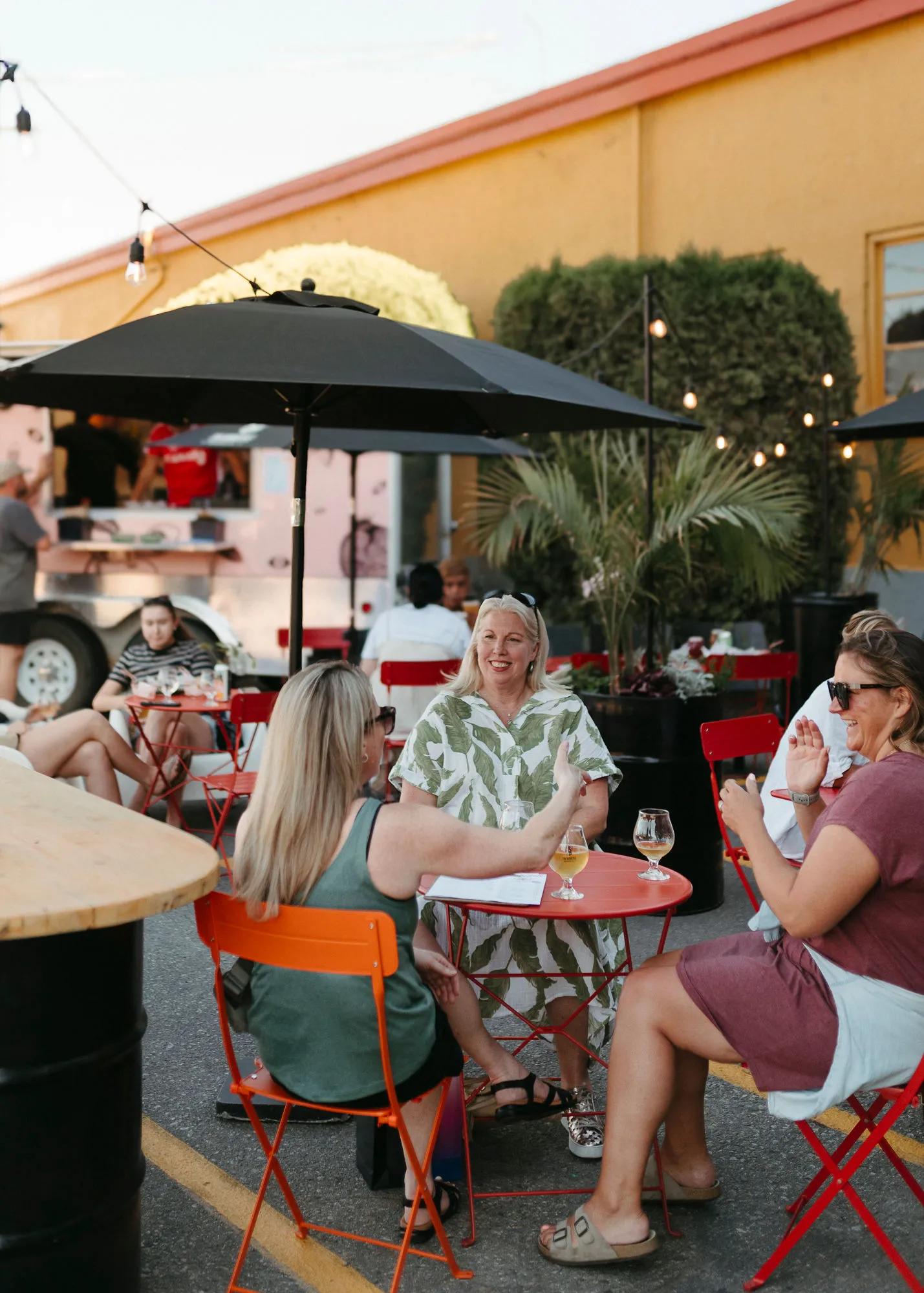 Image of three pizzas at a table with beer