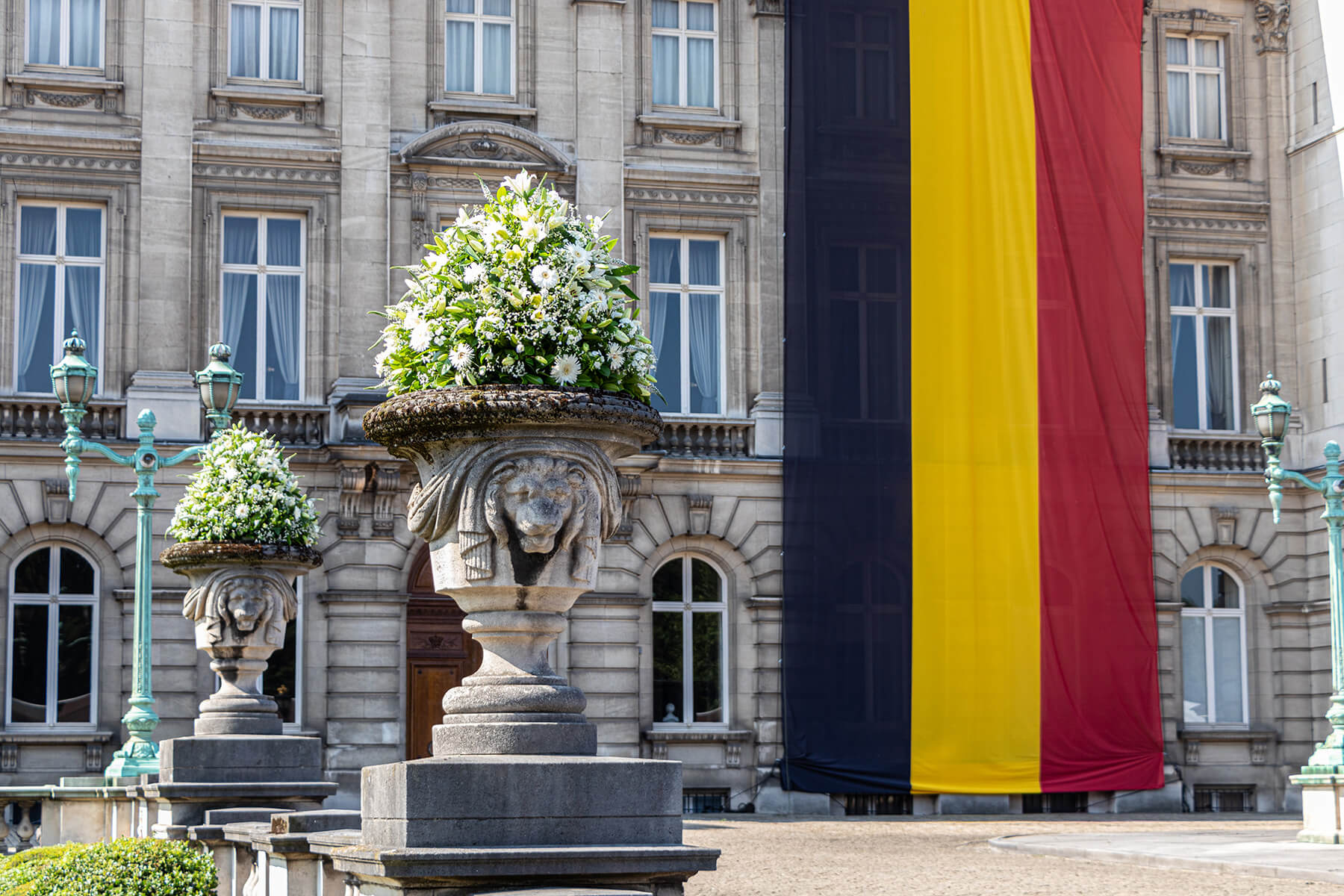 Gigantisch bloemstukken gemaakt voor de koning op de nationale feestdag met de Belgische vlag op de achtergrond.