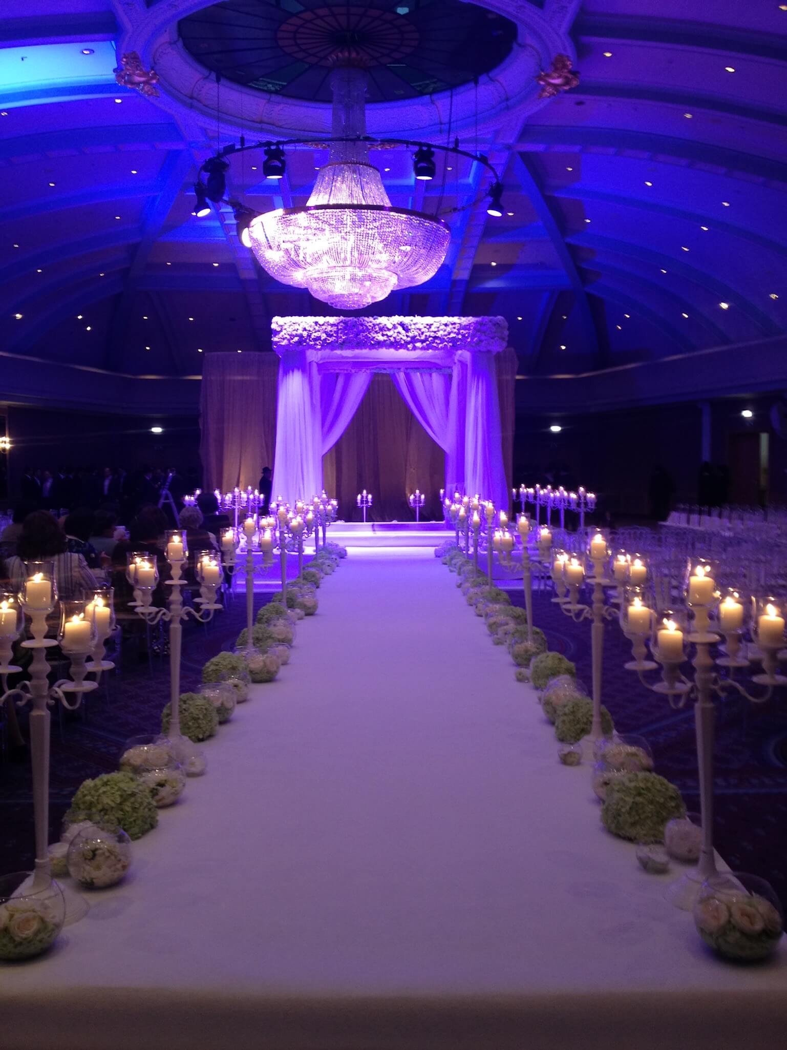 Bijzonder aangeklede ceremonie met verlicht gangpad en grote luster.