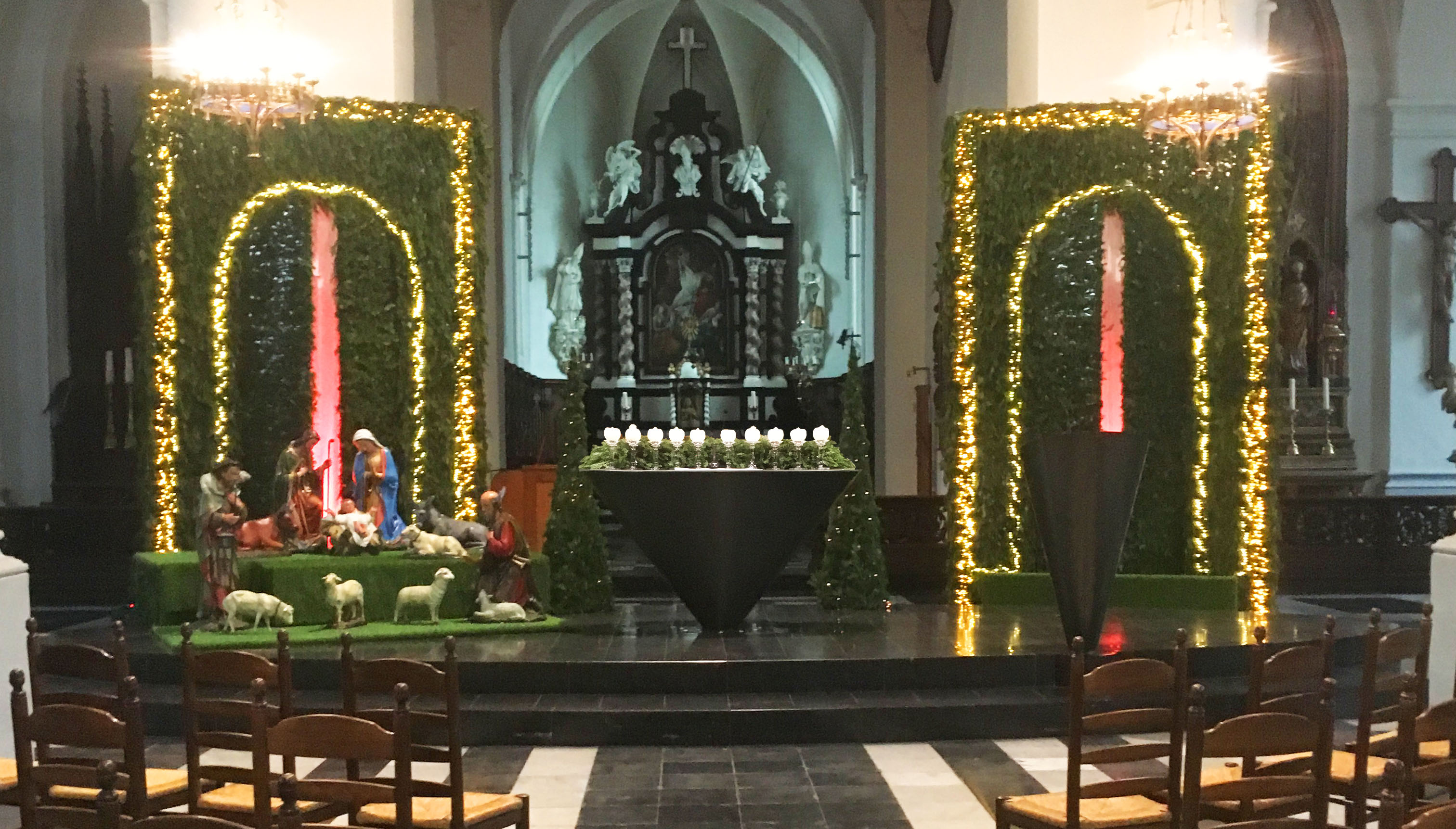 Bijzondere aankleding van de kerk. Paneel links en rechts in het groen met rode verlichting centraal.