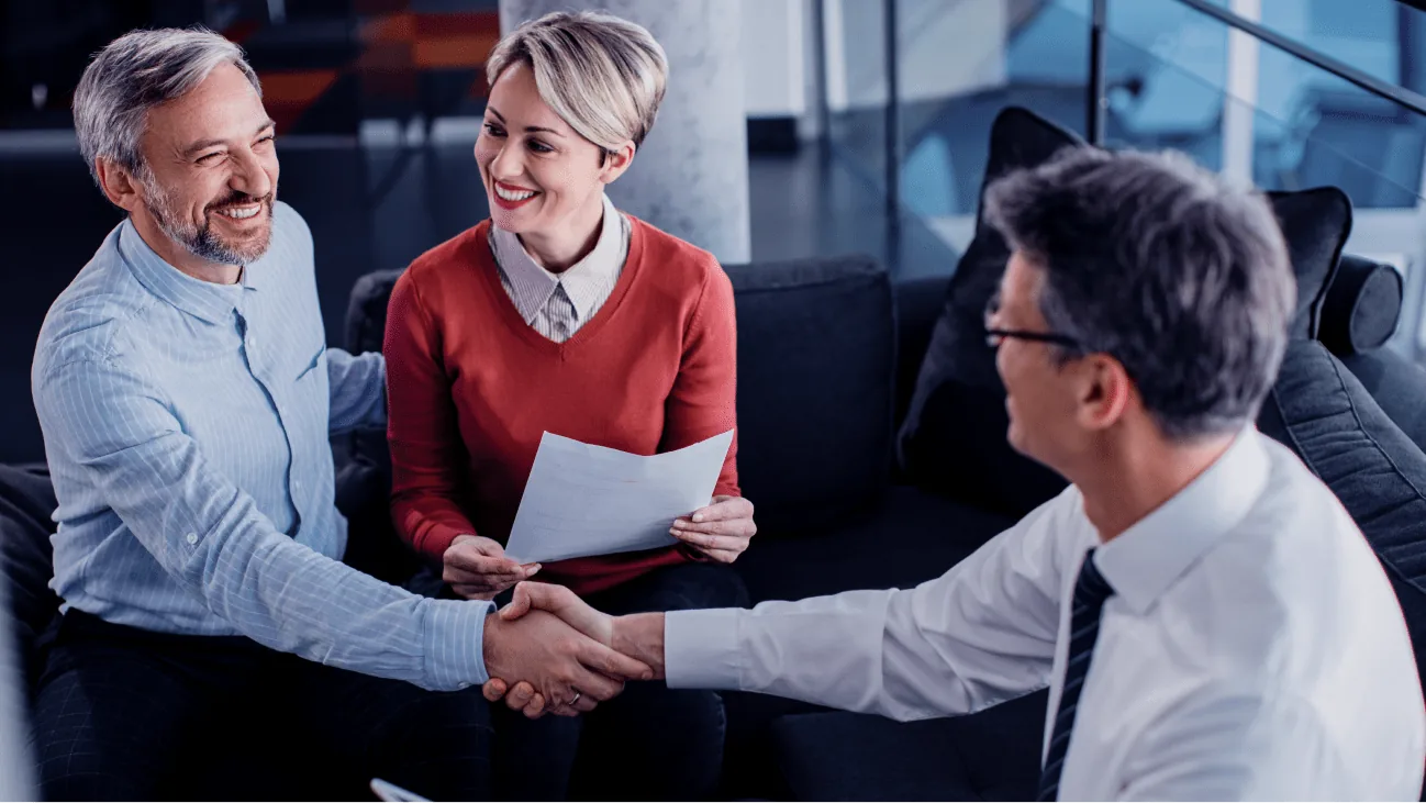 Business professionals shaking hands in a modern office, discussing SaaS security solutions and collaboration.