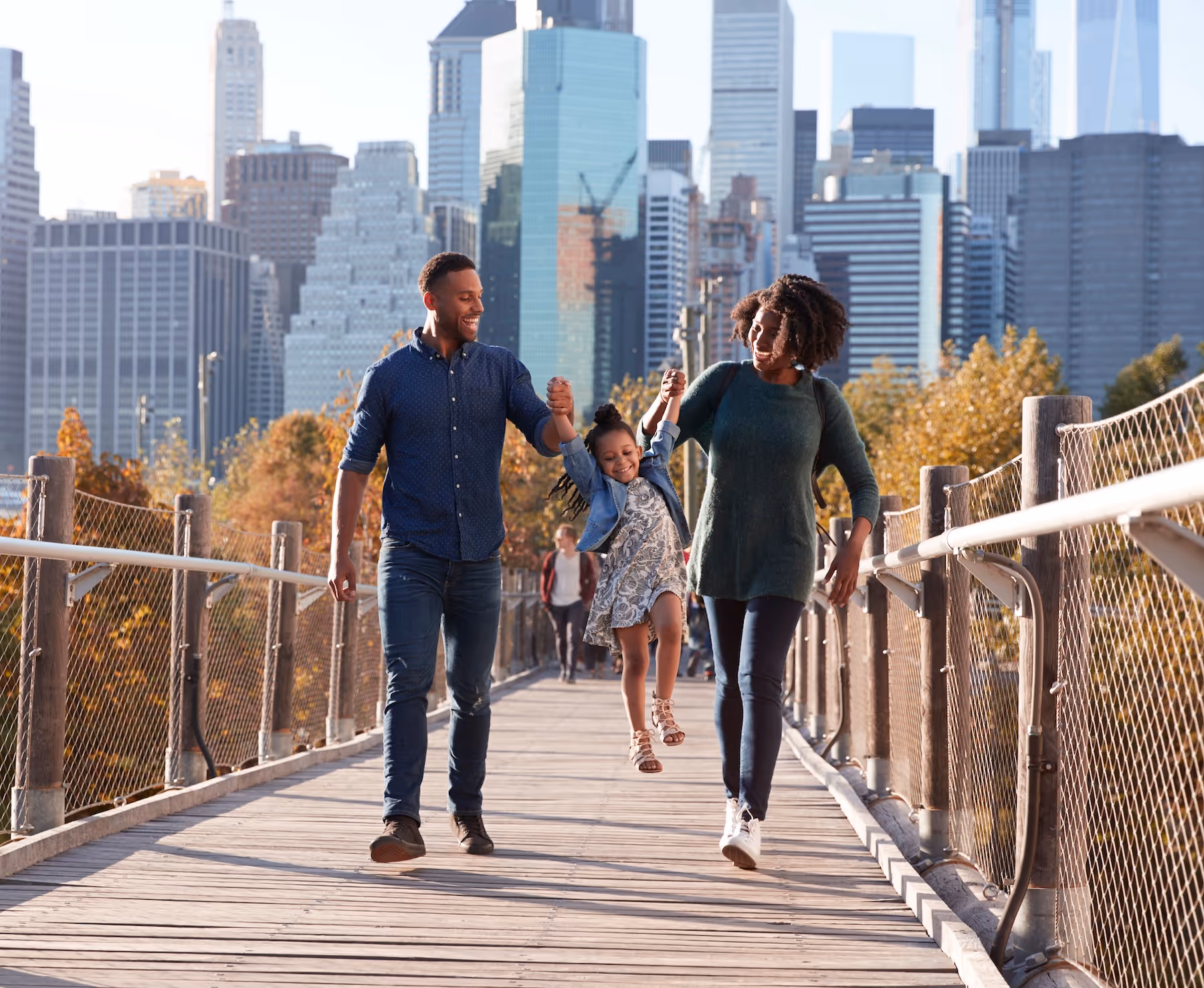 Parents walking across a bridge with their child