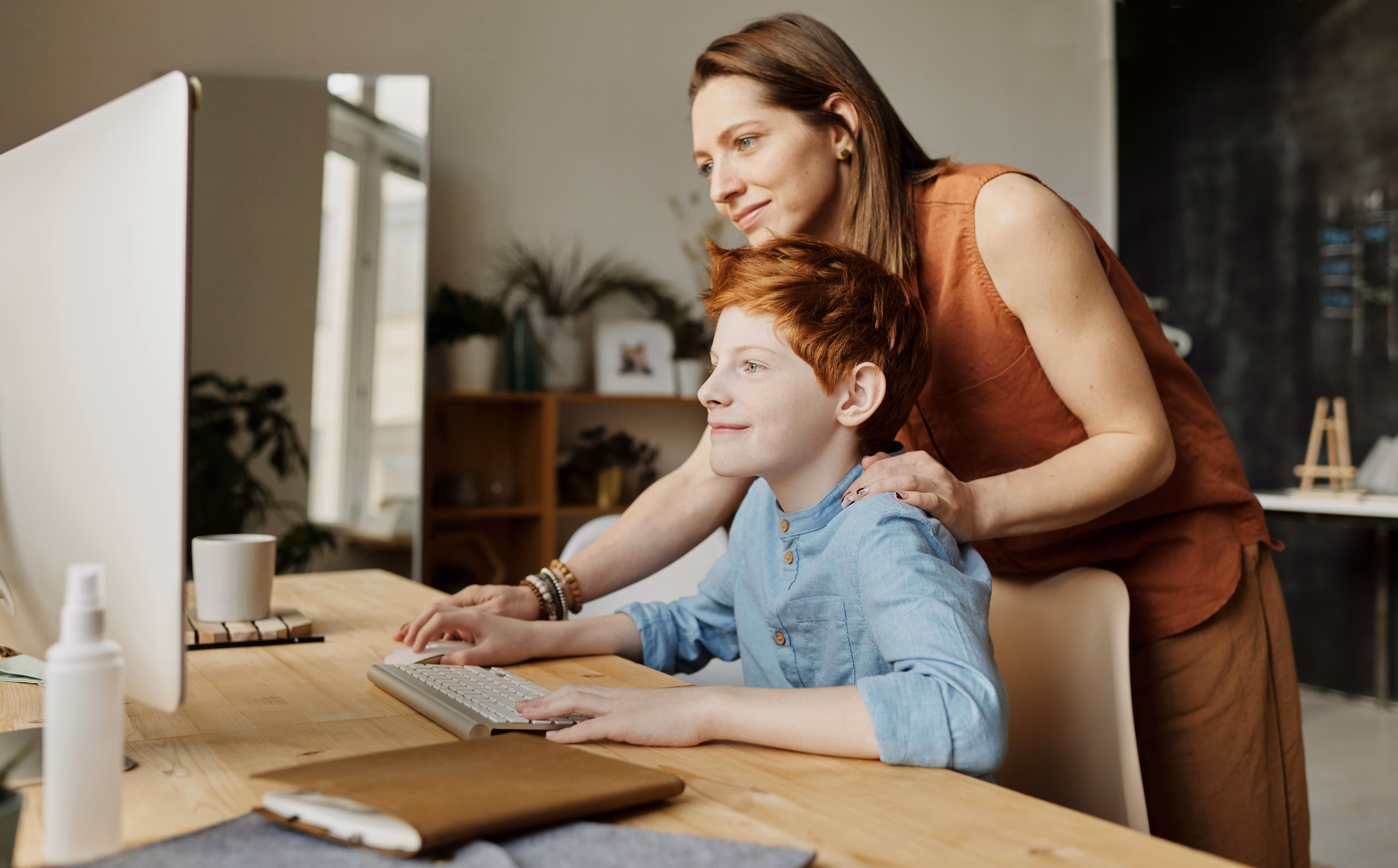 A mom helping her son use the computer