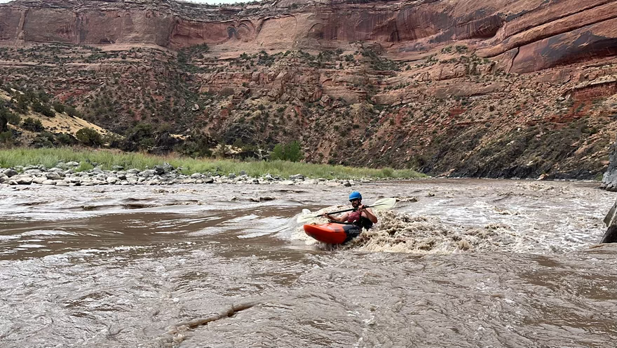person kayaking in a rapid