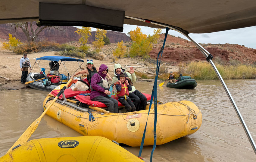 group of people dressed warmly on a raft on the colorado river