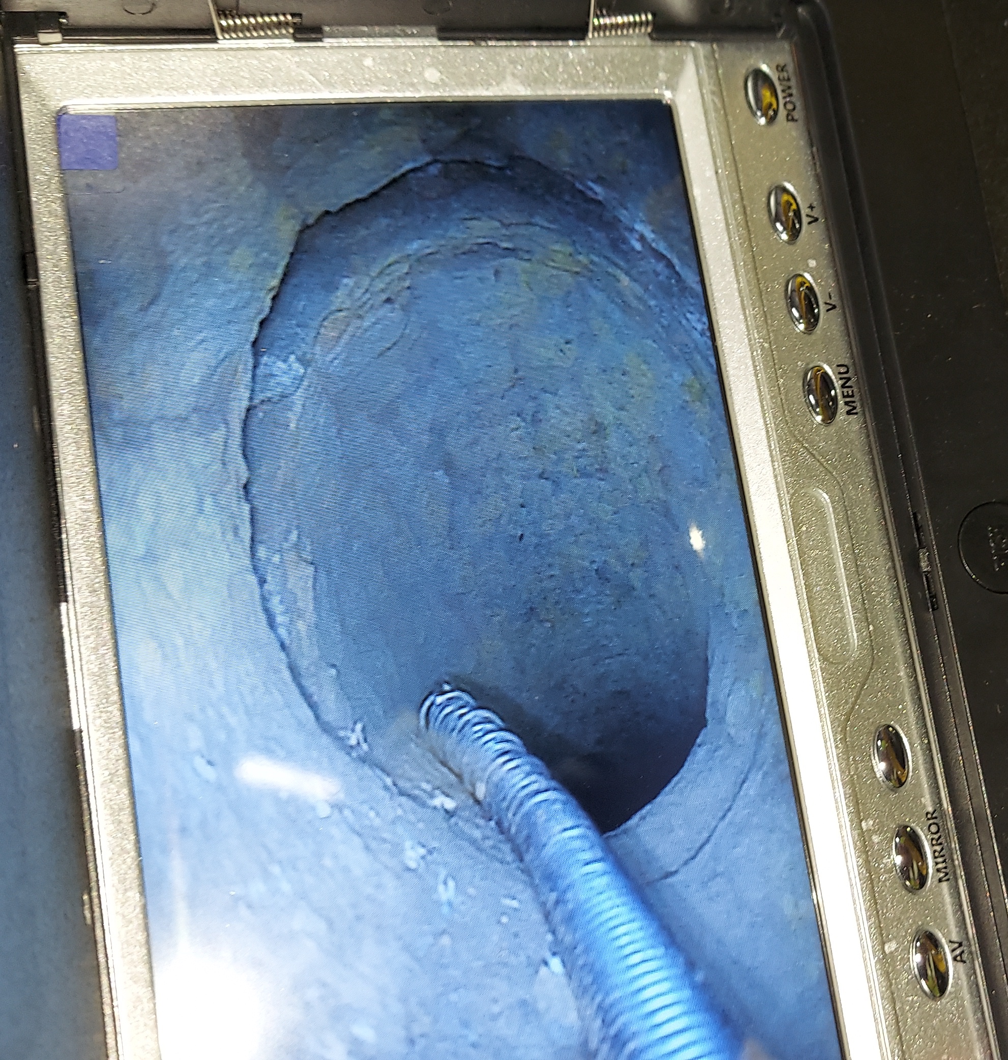 An image of a screen, showcasing the inside of a pipe from a video pipe inspection.