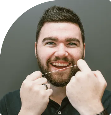 young man with dental floss on hand