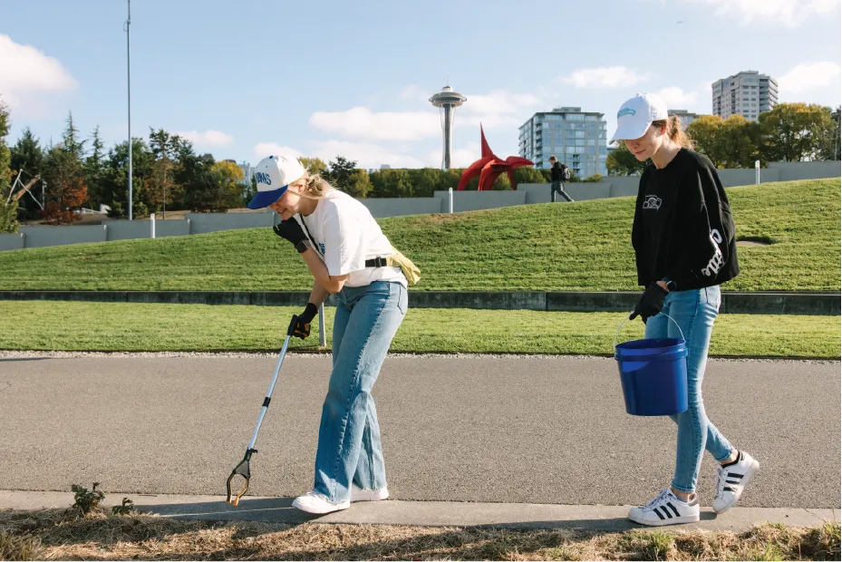Two Seahawks employees picking up litter
